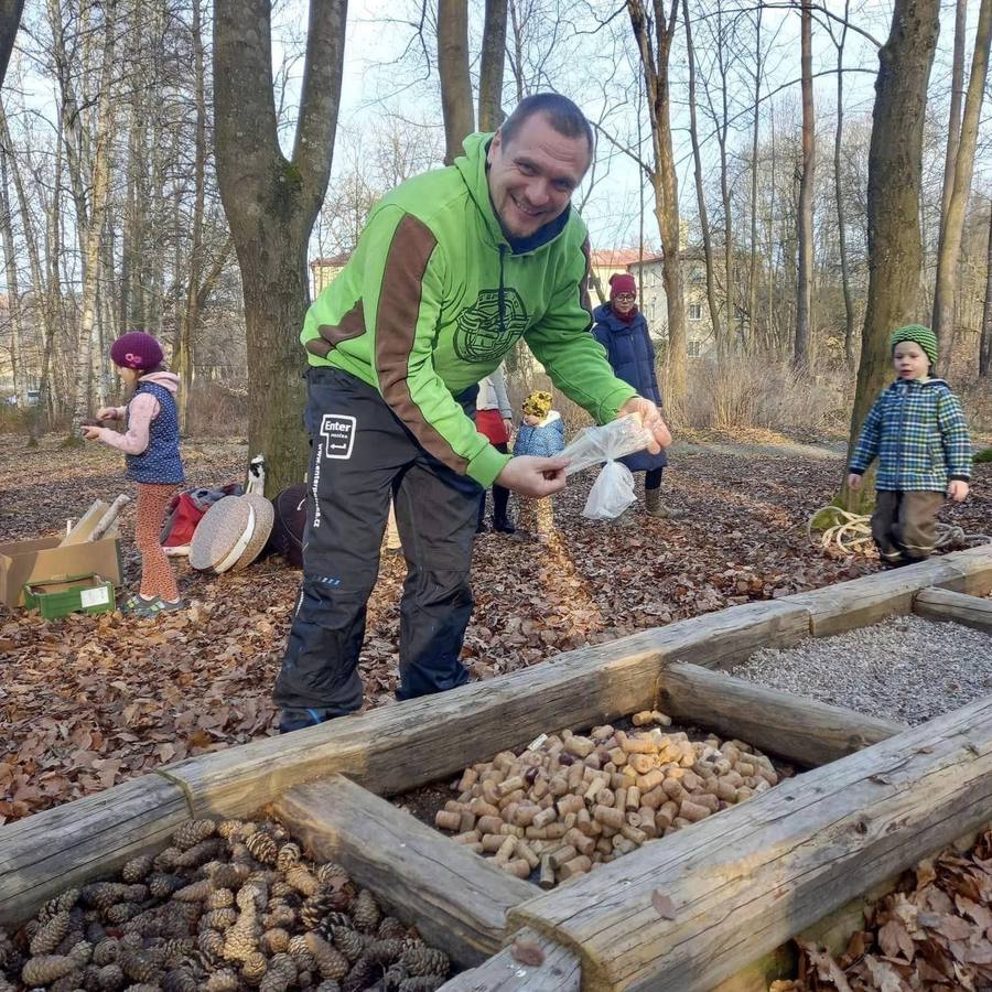 Lidé doplňují náplň jednotlivých polí chodníku v zimě, mezi holými stromy