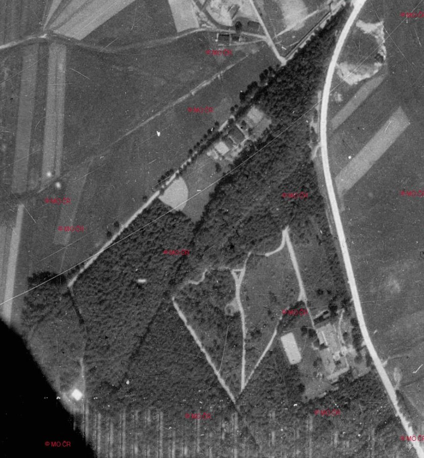 Letecký měřický snímek Liboháje a okolí z roku 1937: tmavá plocha lesa s viditelnou sítí cest, kolem pole